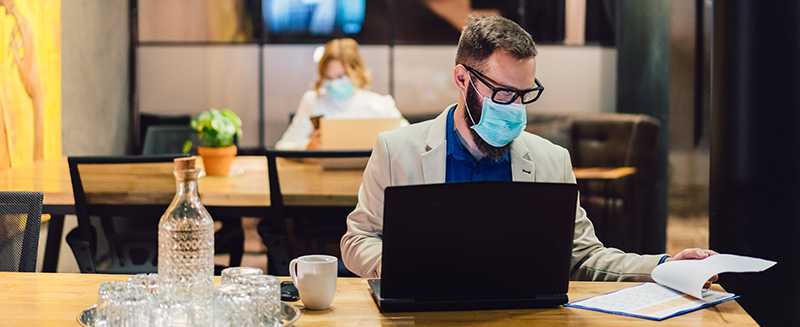People wearing face masks distancing work 