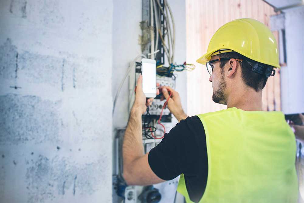 man testing electricty using mobile